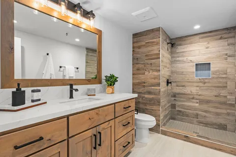 a bathroom with a granite countertop sink a toilet and a mirror