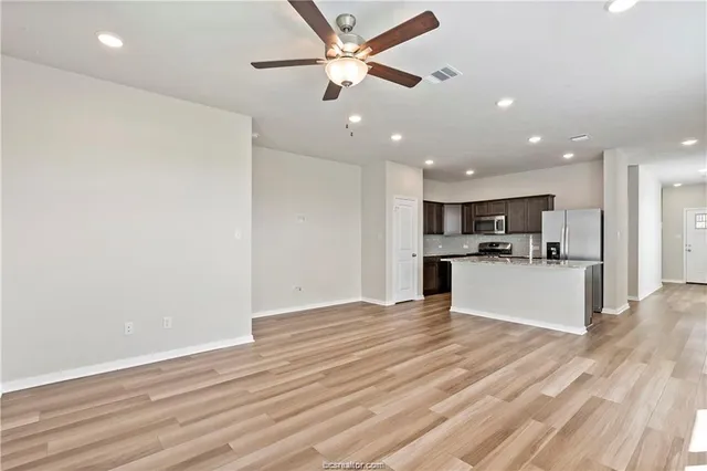 a view of kitchen with refrigerator and ceiling fan