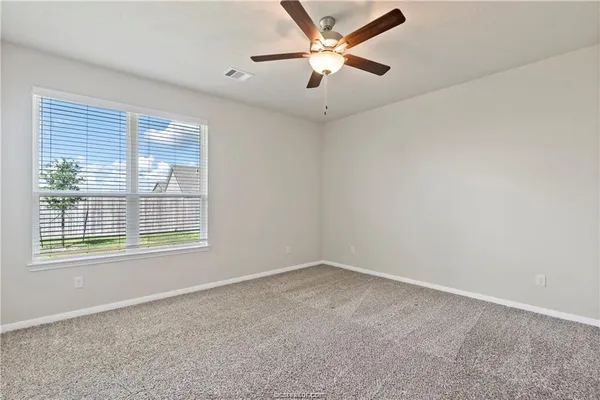an empty room with a window and a fan
