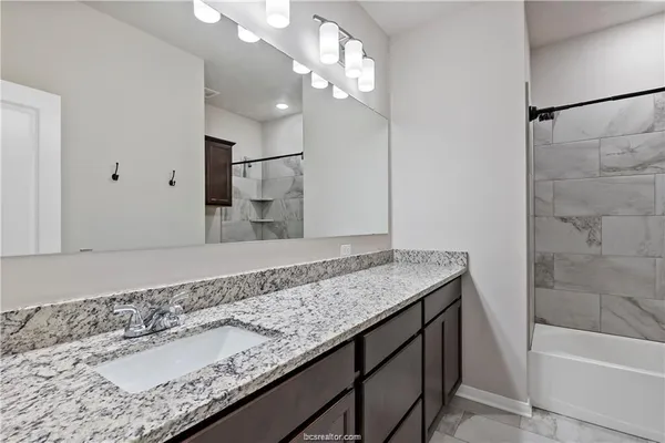 a bathroom with a granite countertop sink and a mirror