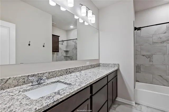 a bathroom with a granite countertop sink and a mirror