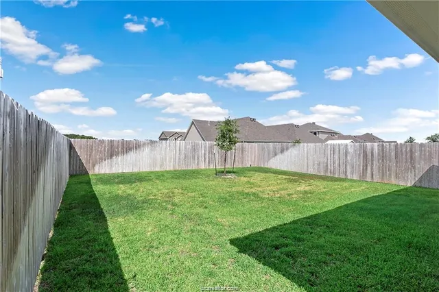 a view of a backyard with wooden fence