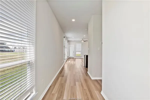 a view of a hallway with wooden floor and staircase