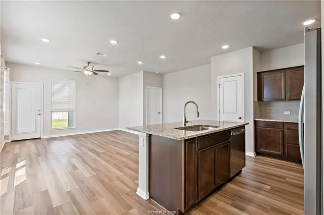 a kitchen with stainless steel appliances granite countertop a sink stove and refrigerator