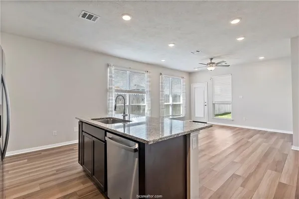 a kitchen with granite countertop a sink and a wooden floor