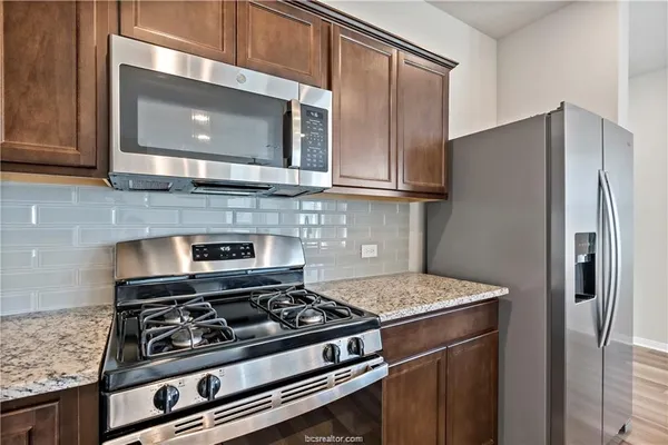 a kitchen with stainless steel appliances granite countertop a stove and a refrigerator