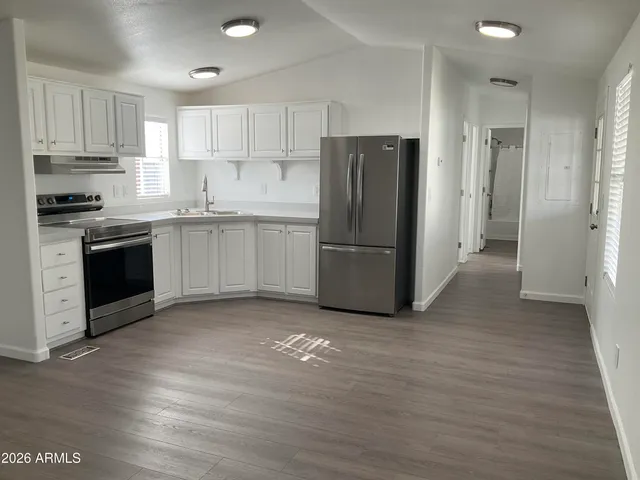 a kitchen with granite countertop a refrigerator and a stove top oven