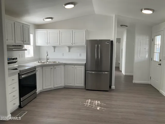a kitchen with a refrigerator sink and cabinets