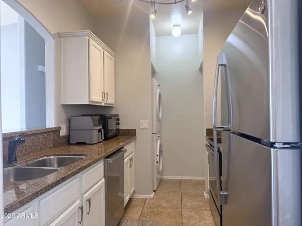 a kitchen with stainless steel appliances granite countertop a refrigerator and a sink