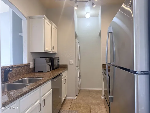 a kitchen with stainless steel appliances granite countertop a refrigerator and a sink