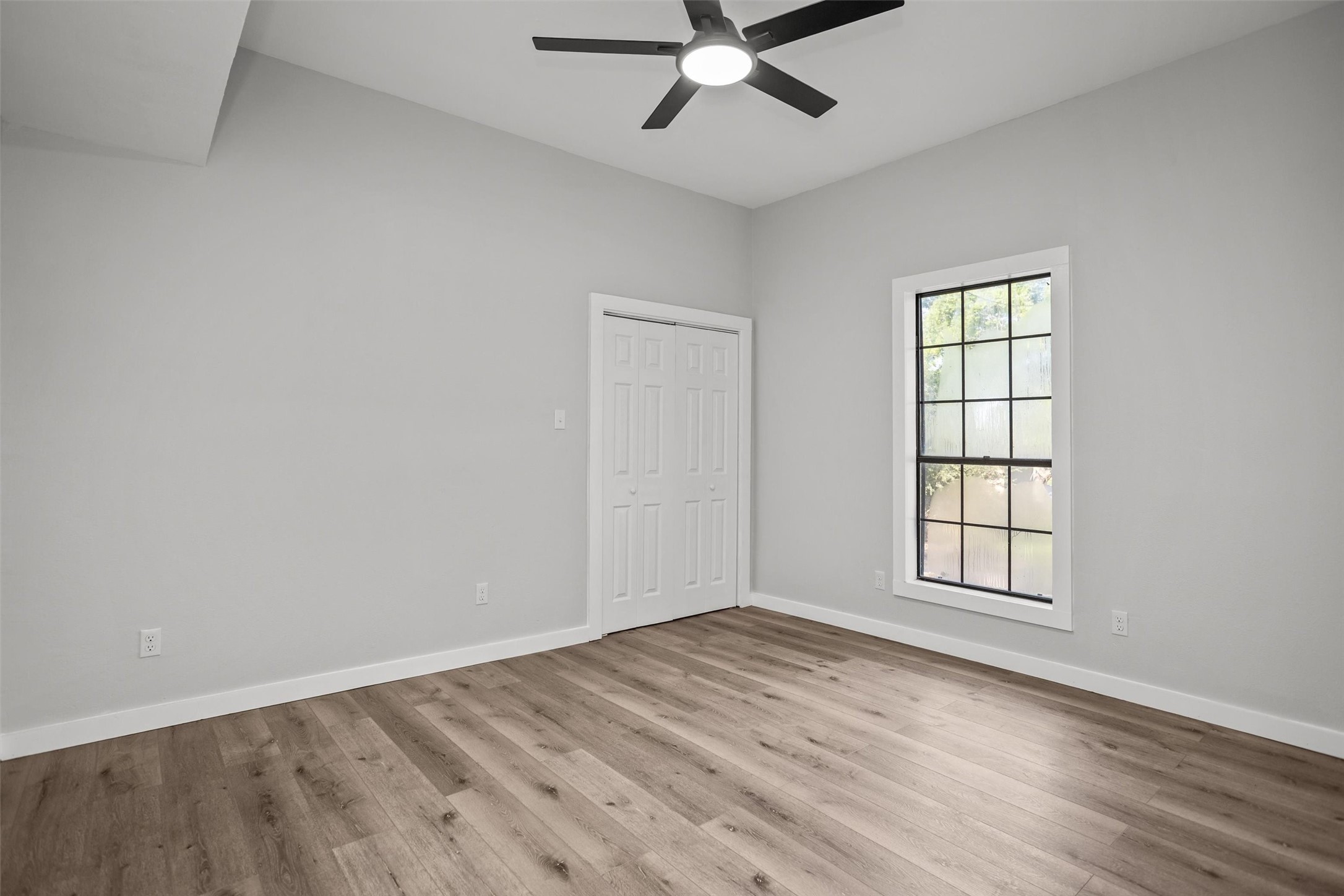 170 Noble Street Lovelady, TX 75851 - Photo 12 of 23 an empty room with wooden floor fan and windows