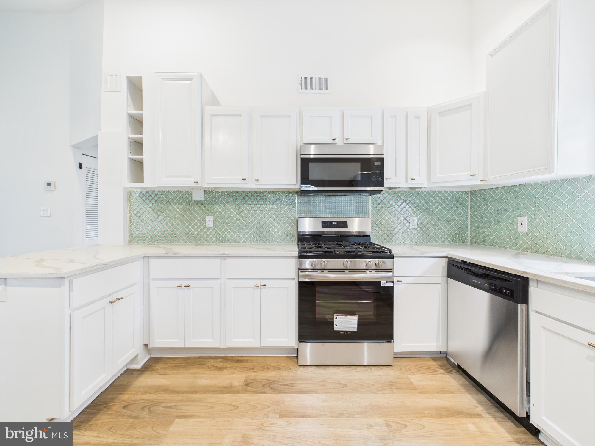 944 Balboa Avenue Capitol Heights, MD 20743 - Photo 12 of 49 a kitchen with stainless steel appliances granite countertop a stove a sink and a microwave
