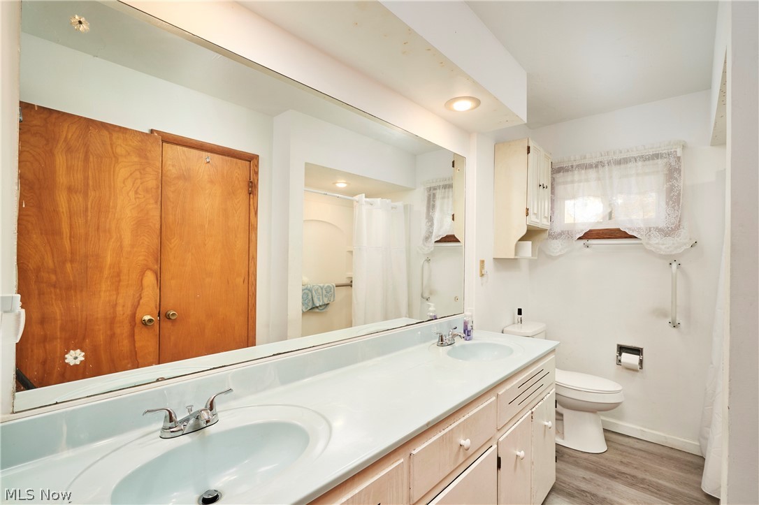 2941 Sweitzer Road Uniontown, OH 44685 - Photo 12 of 16 Full bathroom featuring light wood-style floors, a shower with curtain, and double vanity