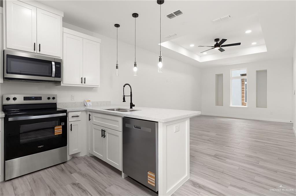 518 East E Loop, Unit 10 Harlingen, TX 78550 - Photo 6 of 14 a kitchen with stainless steel appliances a stove a sink and a microwave