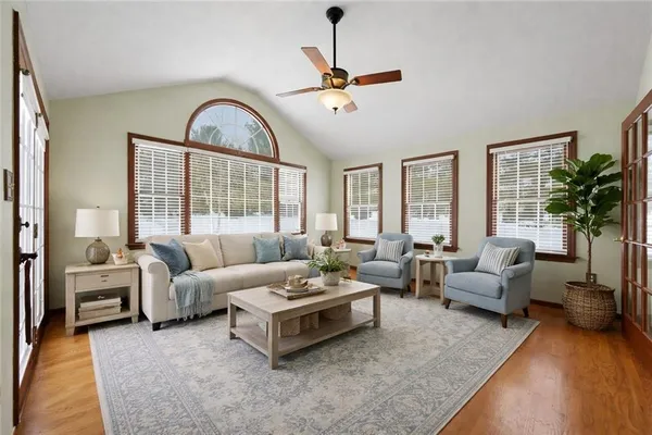 a view of an empty room with window and wooden floor