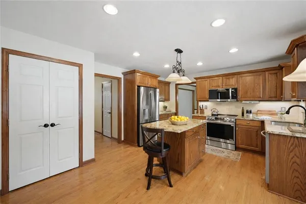 a kitchen with granite countertop a sink stove and refrigerator