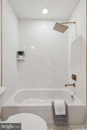 a large spacious bathroom with a large tub and chandelier