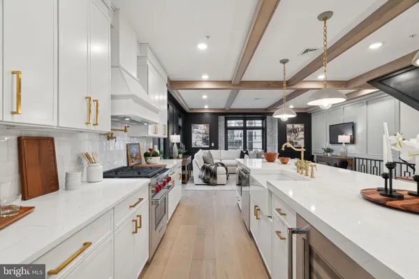 a large white kitchen with lots of counter space sink and a large window