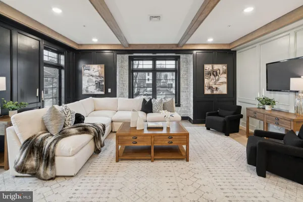 a living room with furniture ceiling fan and a flat screen tv