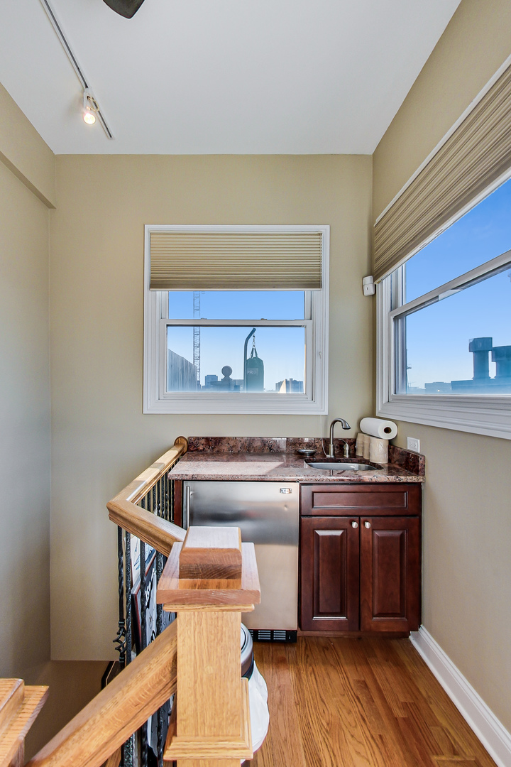 1116 West Hubbard Street, Unit 4W Chicago, IL 60642 - Photo 25 of 32 a kitchen with a stove a sink and wooden floor