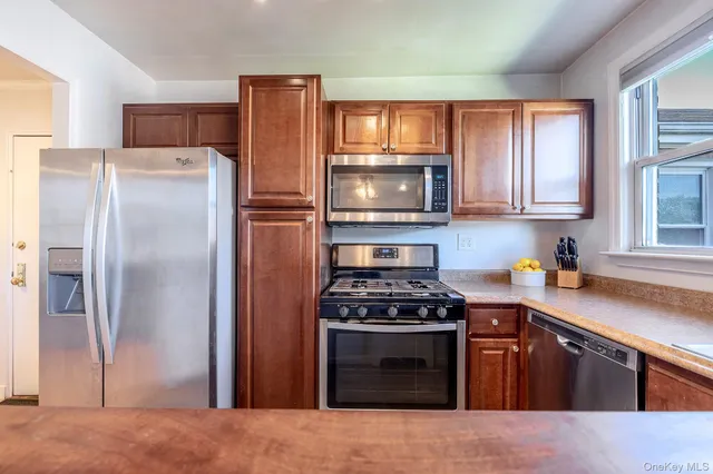 a kitchen with stainless steel appliances granite countertop a refrigerator stove top oven a sink and dishwasher