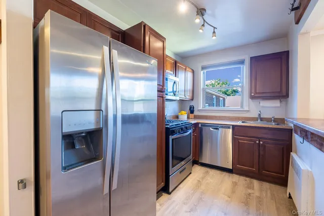 a kitchen with stainless steel appliances granite countertop a refrigerator and a sink