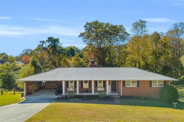 a aerial view of a house next to a yard with plants and trees