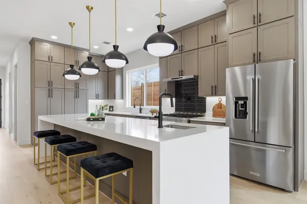 a kitchen with chandelier a refrigerator and a sink