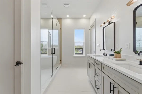 a bathroom with a double vanity sink a mirror and a shower