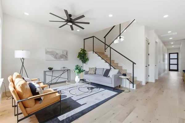 a living room with furniture and a wooden floor