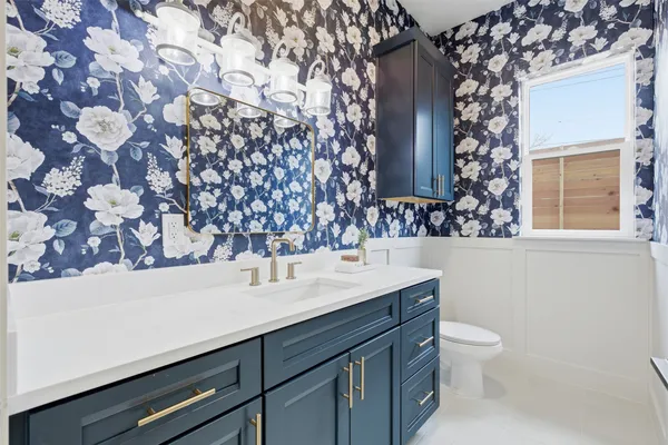 a bathroom with a sink mirror vanity and toilet