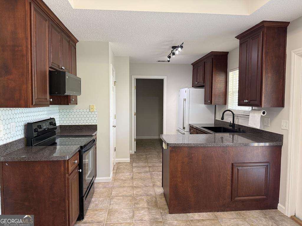 4125 Springruff Drive Valdosta, GA 31602 - Photo 5 of 22 a kitchen with kitchen island granite countertop a sink counter top space appliances and cabinets