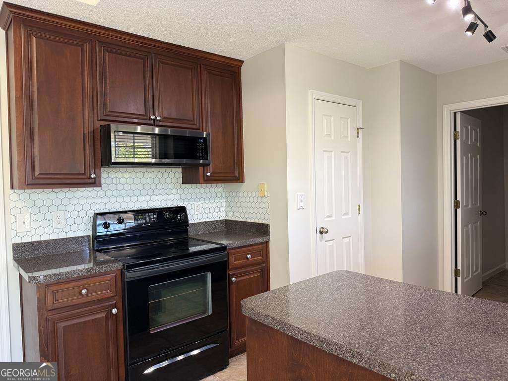 4125 Springruff Drive Valdosta, GA 31602 - Photo 6 of 22 a kitchen with granite countertop wooden cabinets and stainless steel appliances