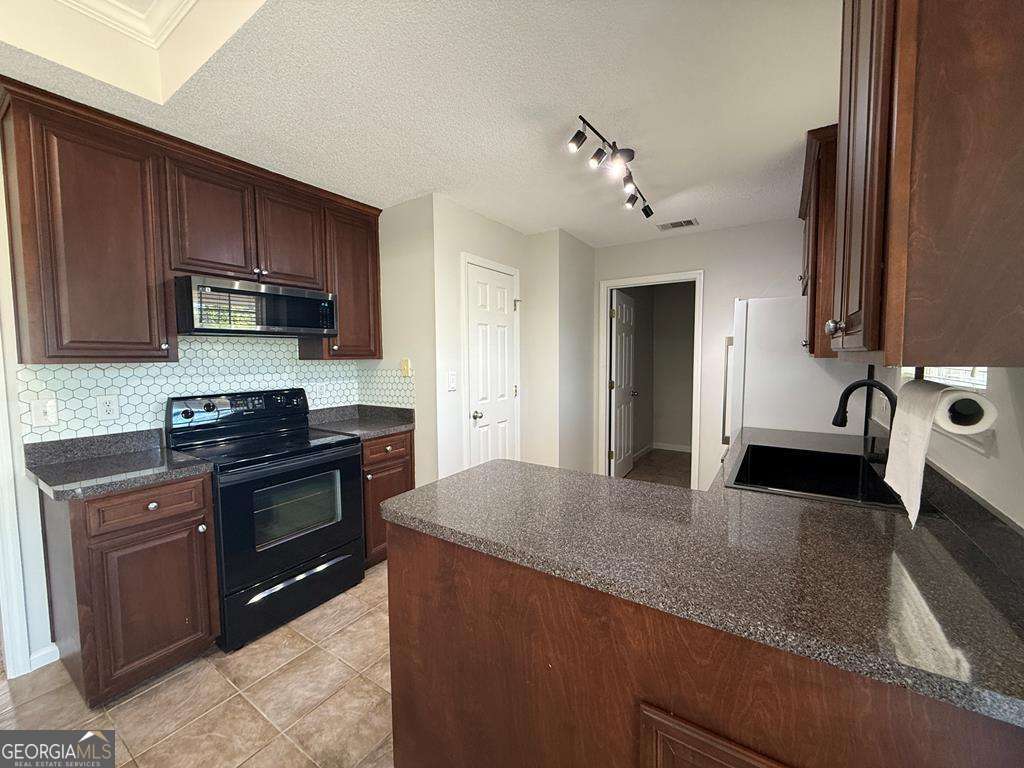 4125 Springruff Drive Valdosta, GA 31602 - Photo 7 of 22 a kitchen with stainless steel appliances granite countertop a sink stove and refrigerator