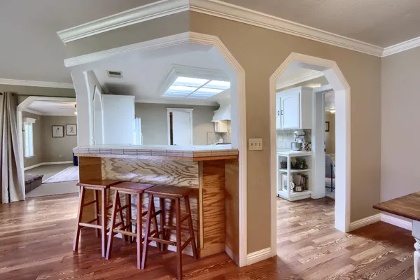 a view of a dining room with furniture a chandelier and wooden floor