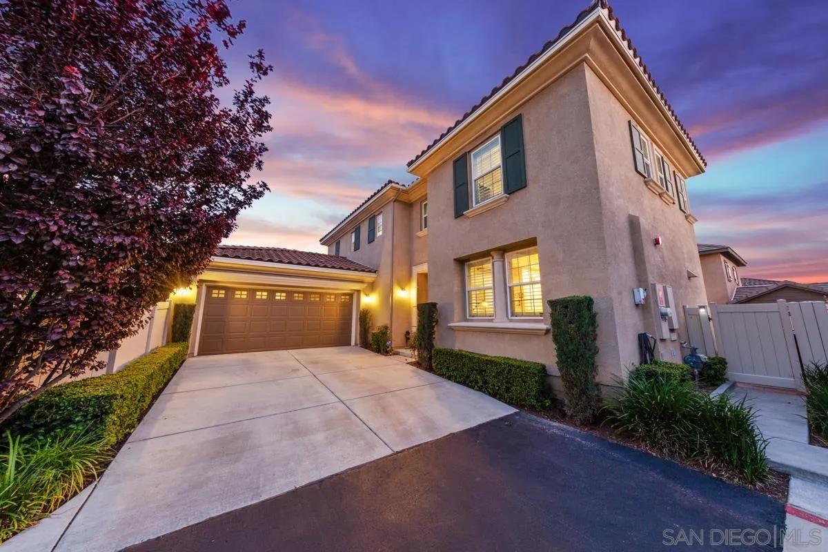 a front view of a house with yard and trees