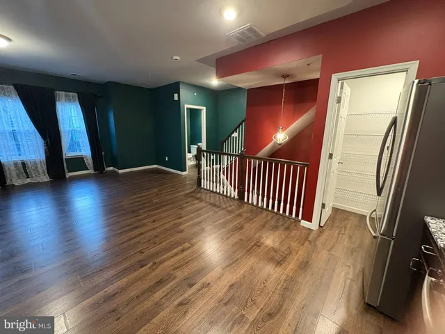 an entryway with wooden floor and windows