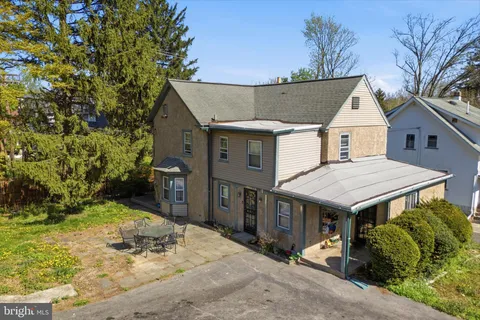 a view of a house with a yard and potted plants