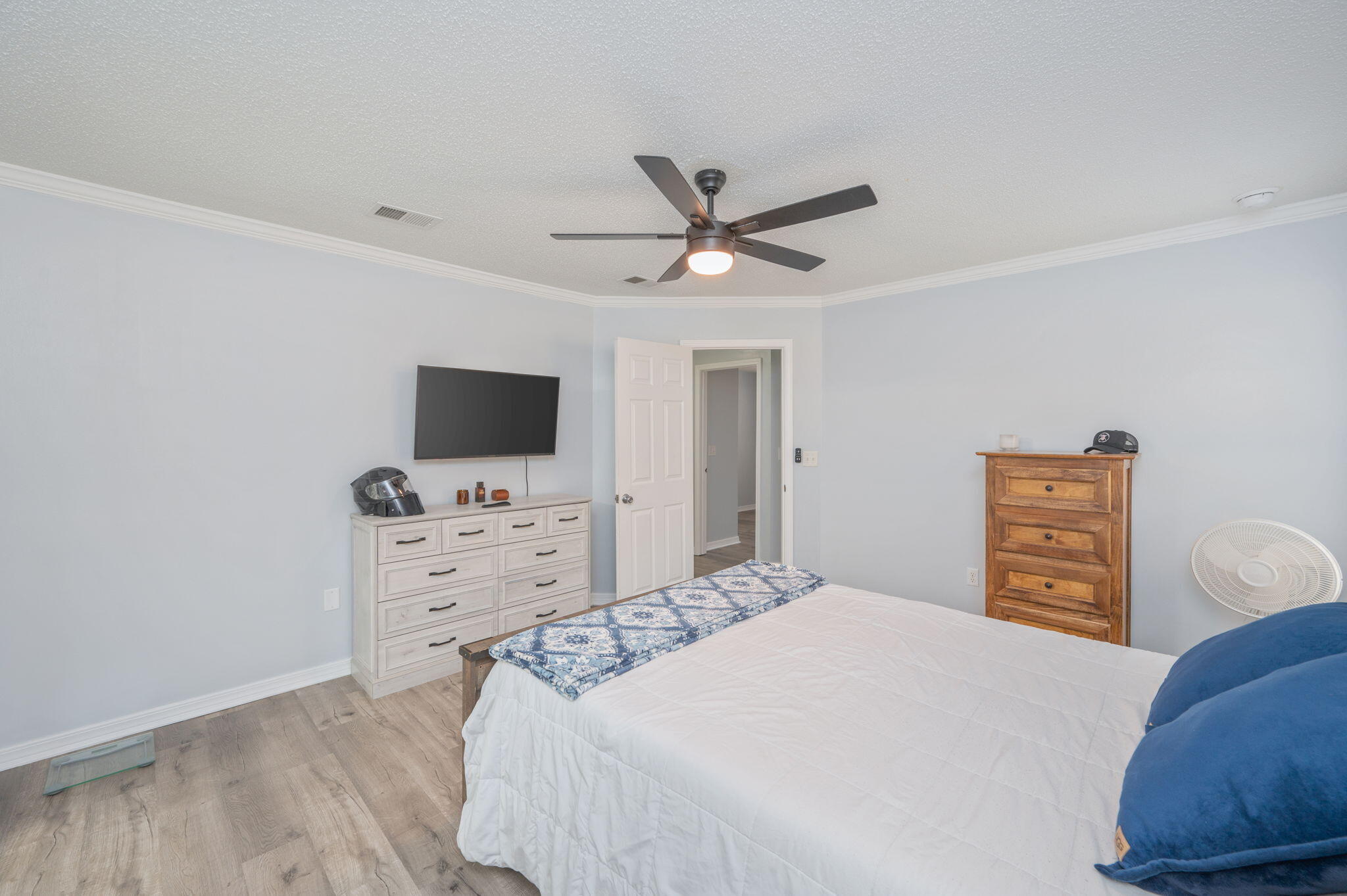 5249 Kervin Road Crestview, FL 32539 - Photo 12 of 27 a bedroom with a bed a flat screen tv and a dresser with a bookshelf