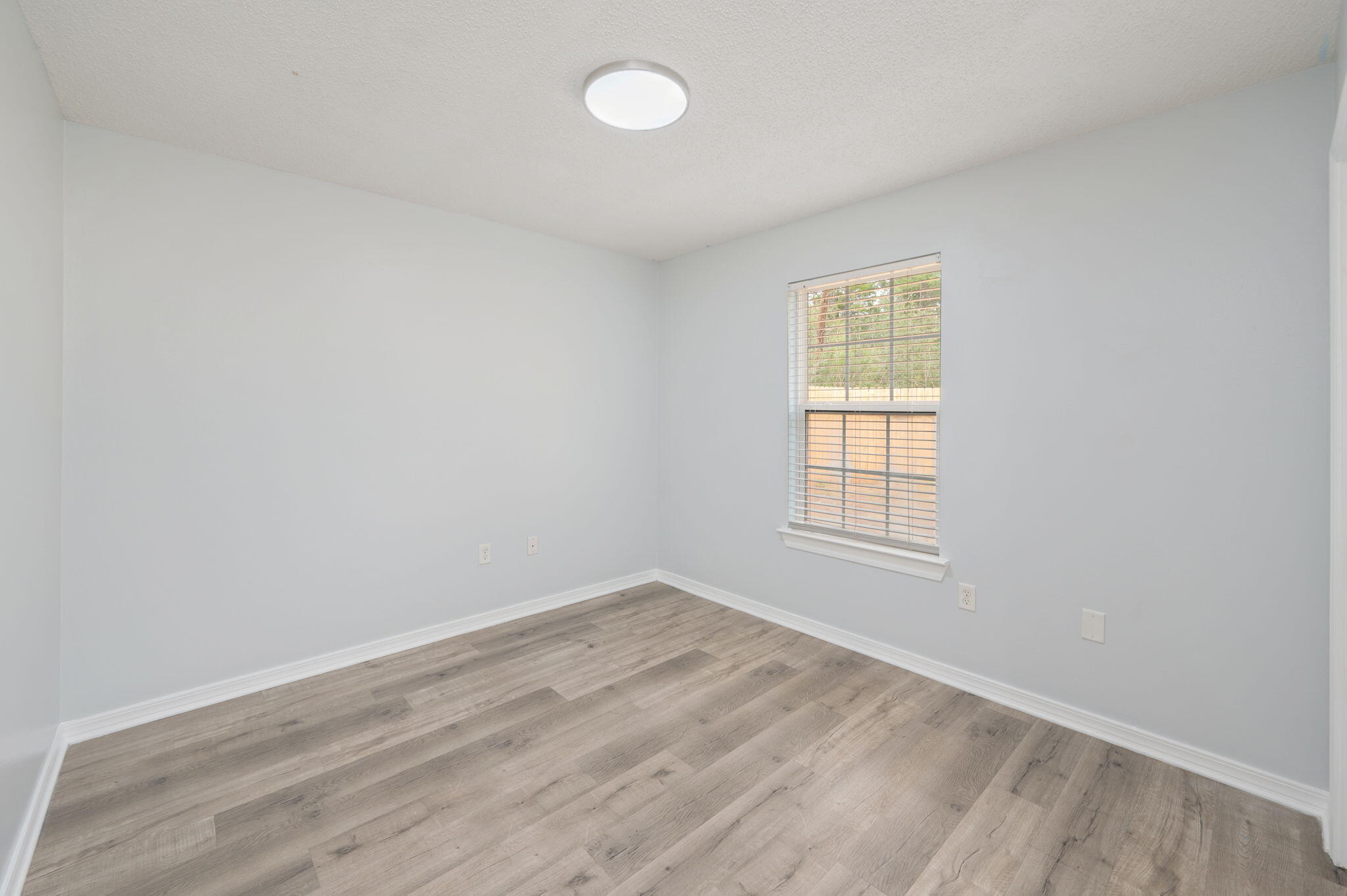 5249 Kervin Road Crestview, FL 32539 - Photo 16 of 27 an empty room with wooden floor and windows
