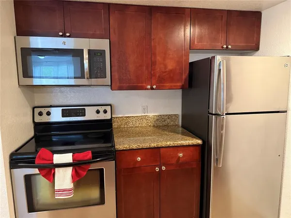a kitchen with granite countertop a sink and a stove