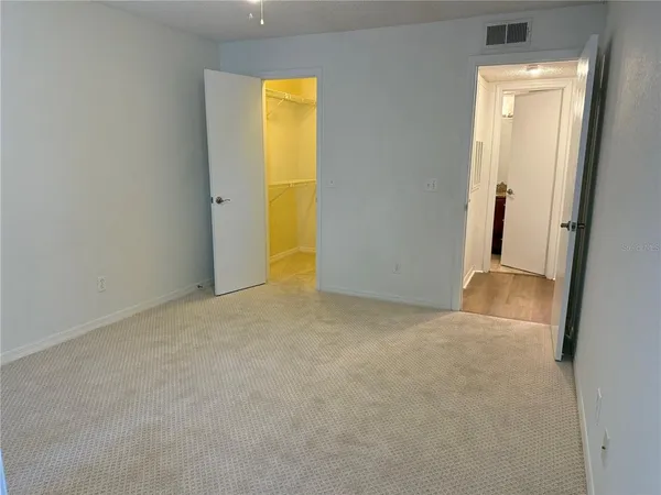 an empty room with windows and fan