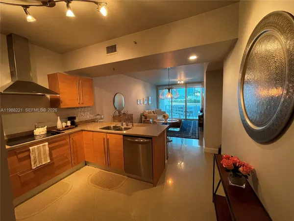 a kitchen with stainless steel appliances granite countertop a sink a stove and a wooden floors