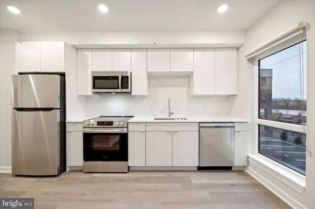 a kitchen with stainless steel appliances granite countertop a stove a sink and a refrigerator