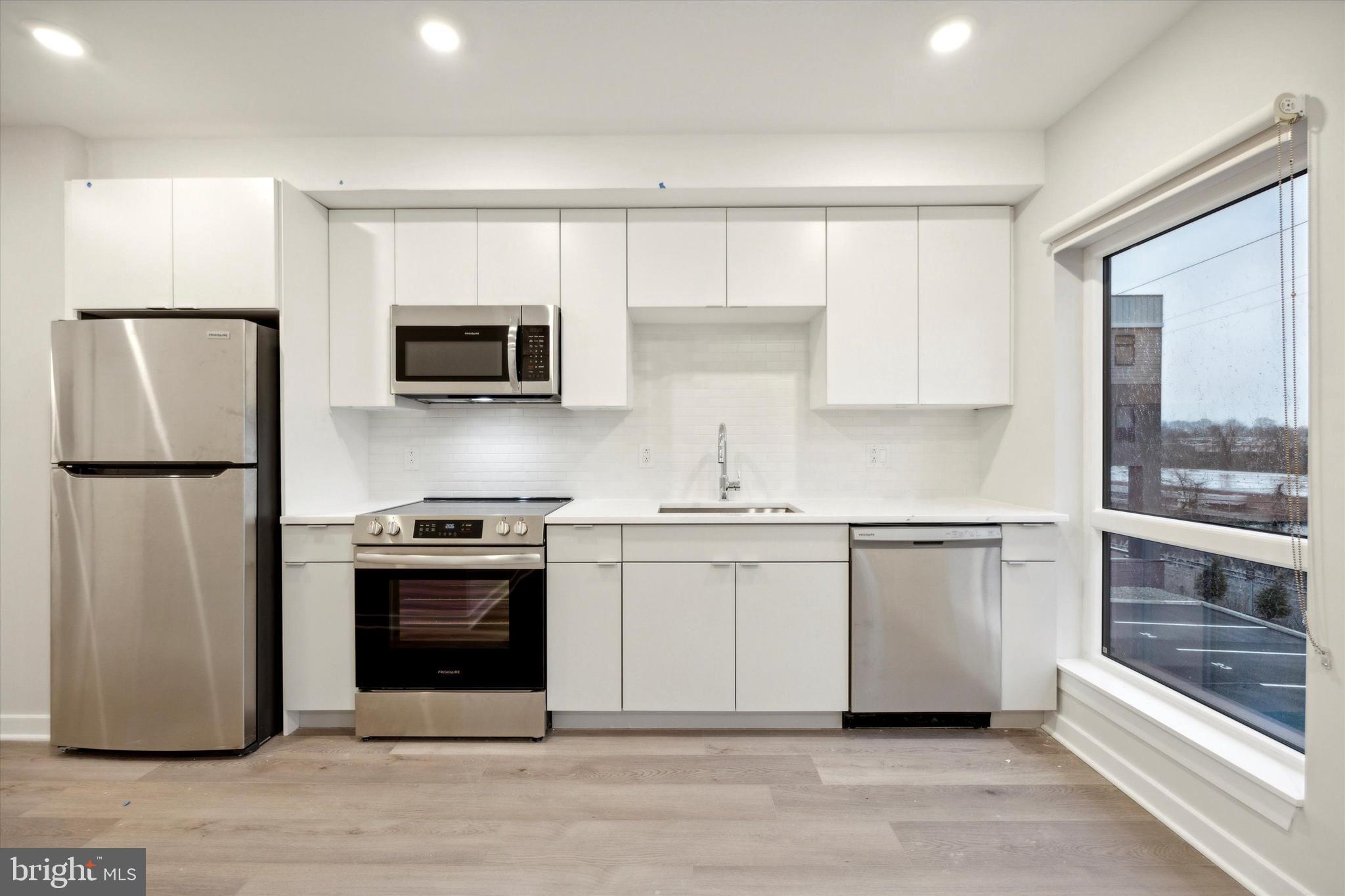 a kitchen with stainless steel appliances granite countertop a stove a sink and a refrigerator