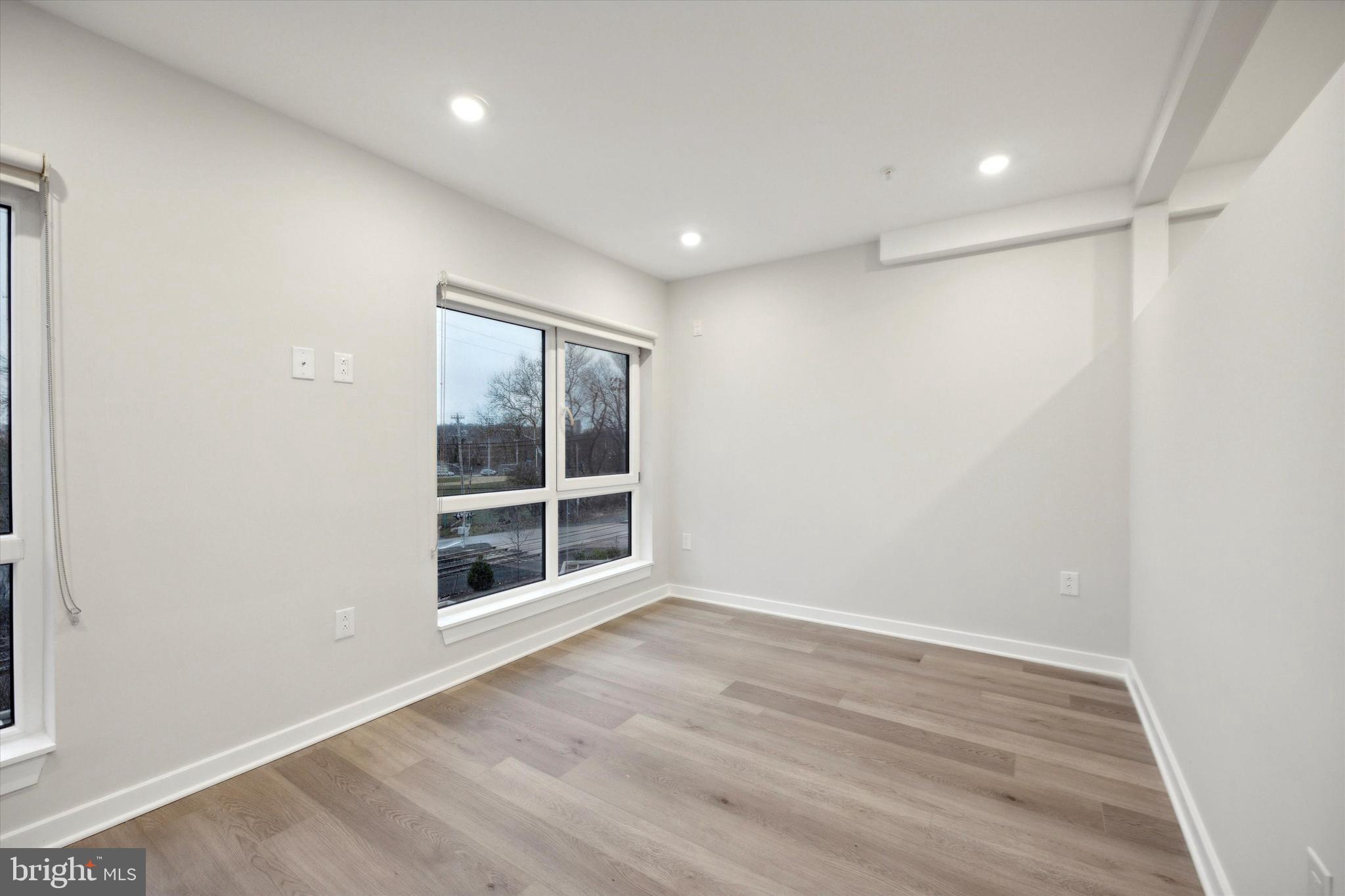 3449 Scotts Lane, Unit A306 Philadelphia, PA 19129 - Photo 5 of 9 a view of an empty room with wooden floor and a window
