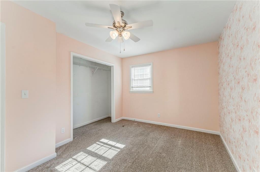 3016 Butler Creek Road Northwest Kennesaw, GA 30152 - Photo 15 of 43 an empty room with chandelier fan and windows
