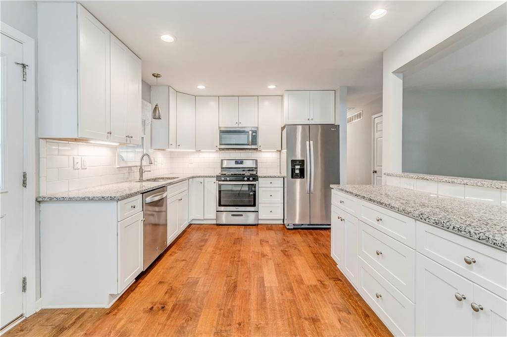 3016 Butler Creek Road Northwest Kennesaw, GA 30152 - Photo 33 of 43 a kitchen with granite countertop a refrigerator stove top oven and sink