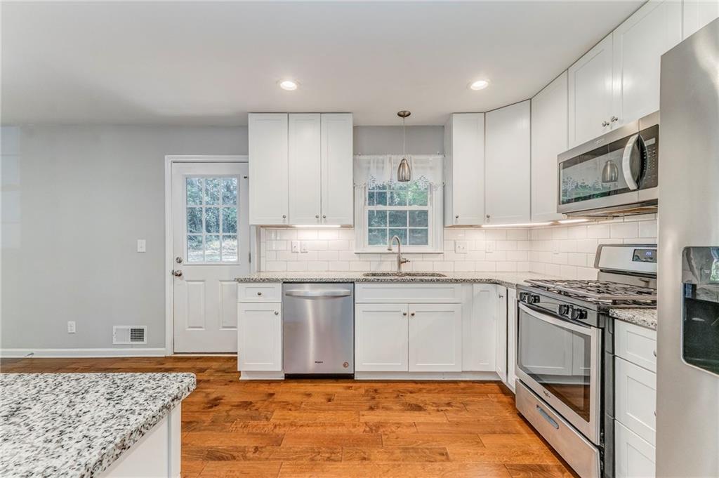 3016 Butler Creek Road Northwest Kennesaw, GA 30152 - Photo 35 of 43 a kitchen with stainless steel appliances granite countertop a stove a sink and a microwave