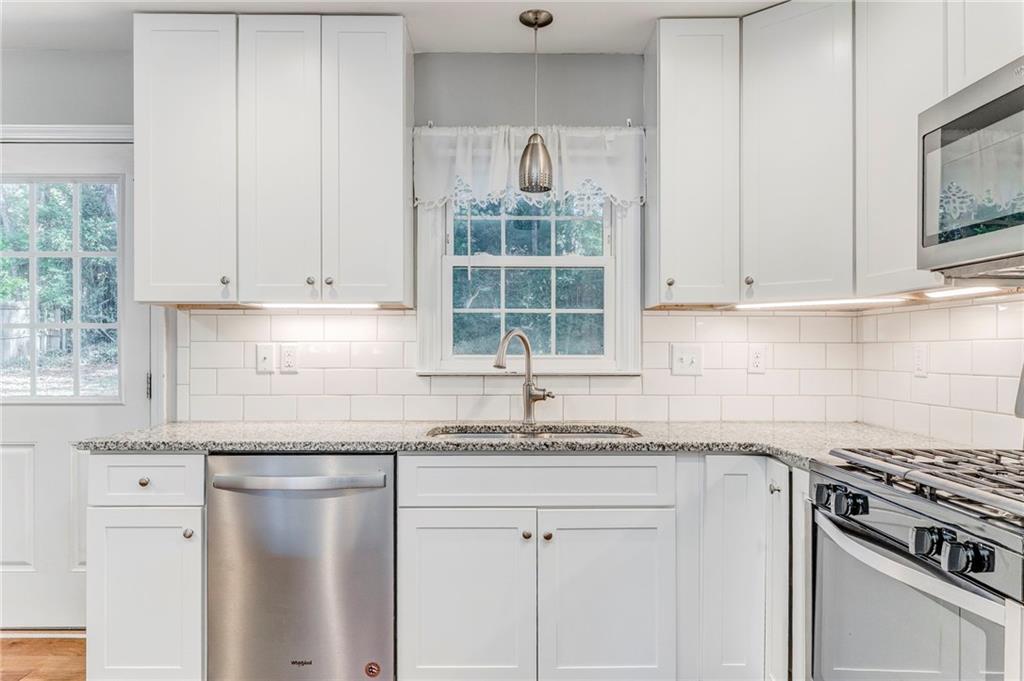 3016 Butler Creek Road Northwest Kennesaw, GA 30152 - Photo 36 of 43 a kitchen with granite countertop a sink stainless steel appliances and white cabinets